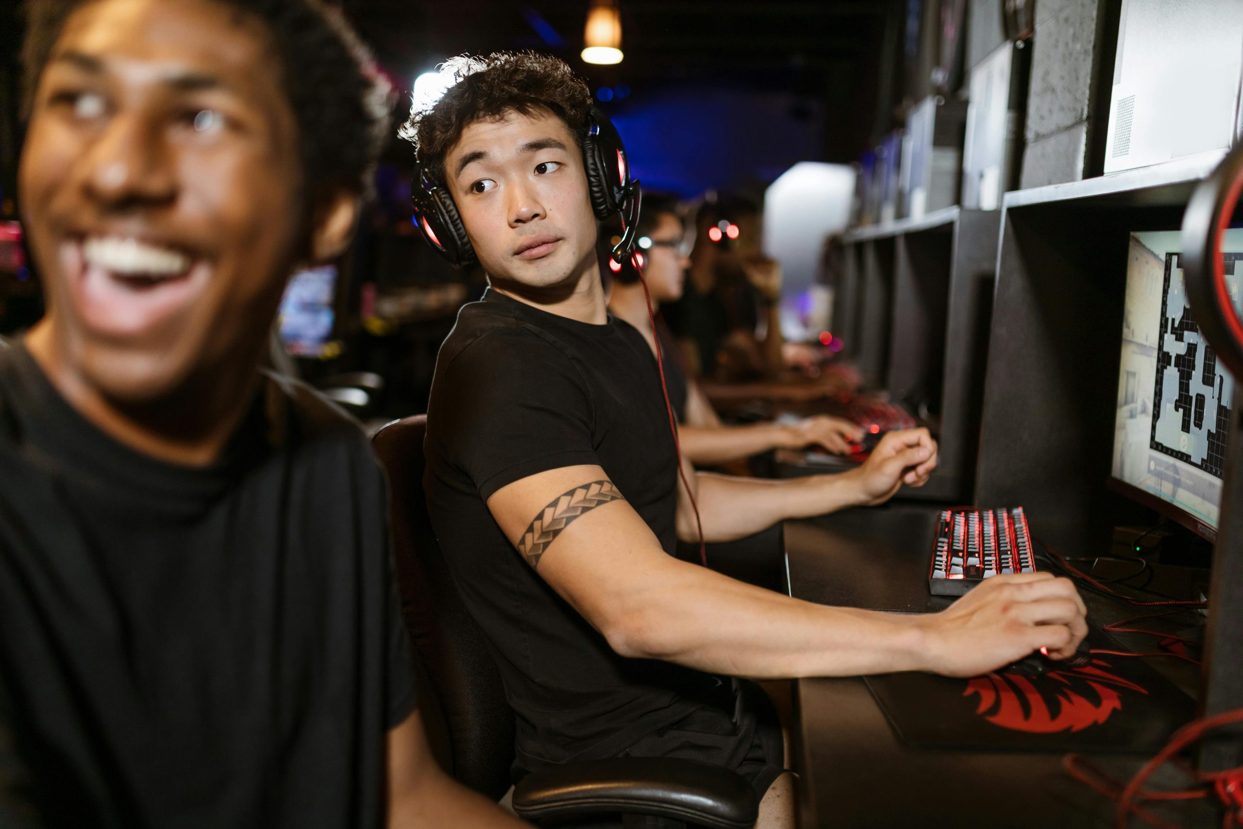 Young gamers engaged in a multiplayer session at an eSports arena with high-end gaming setups.